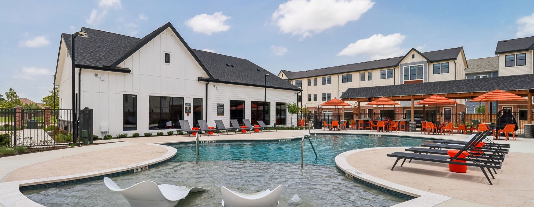 Residents enjoying the saltwater pool with sundeck at Amplify Tomball in Tomball, Texas.