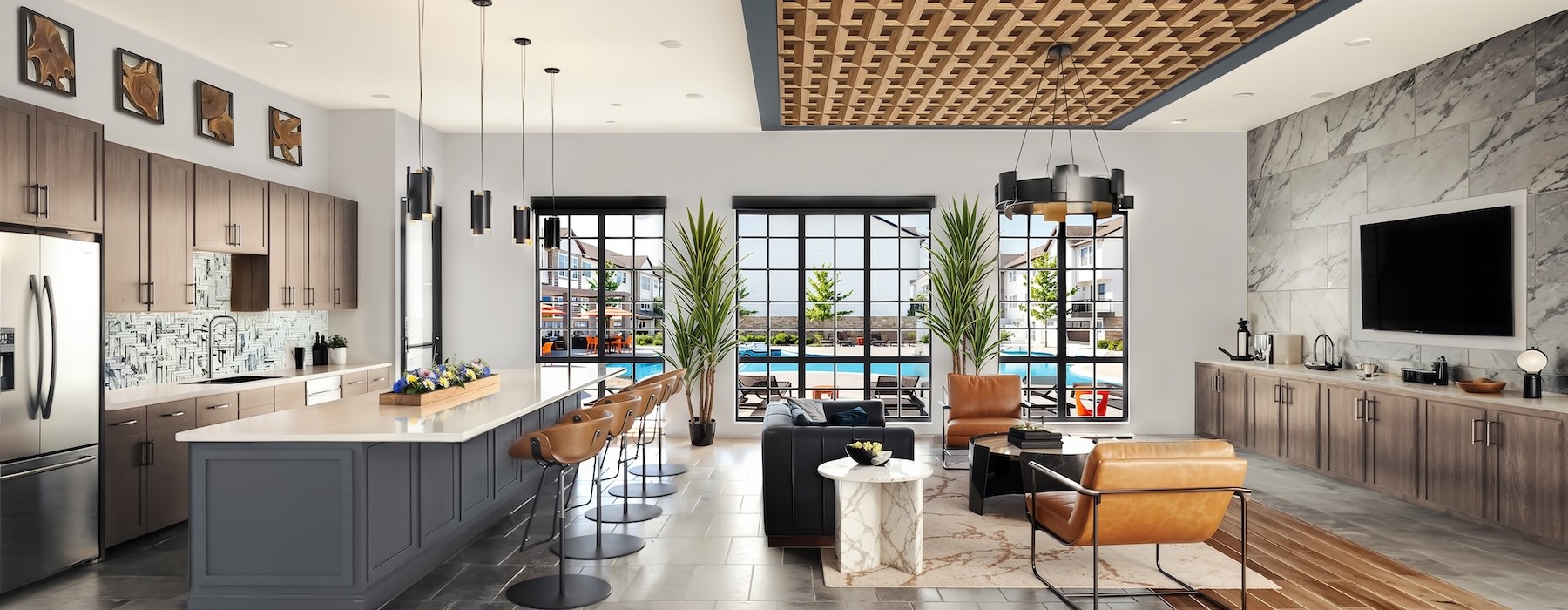 a clubhouse with a kitchen, seating, tables and a tv