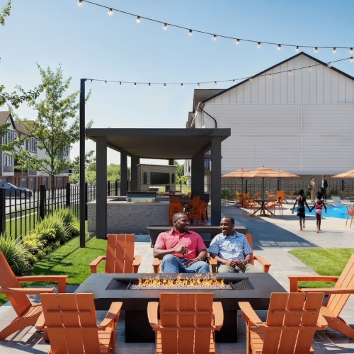 two men sitting in chairs in a patio area