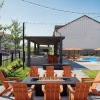 a patio area with a fire pit and chairs