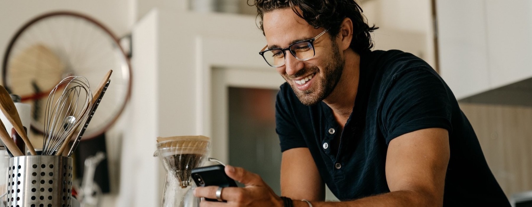 a man smiling while holding a phone