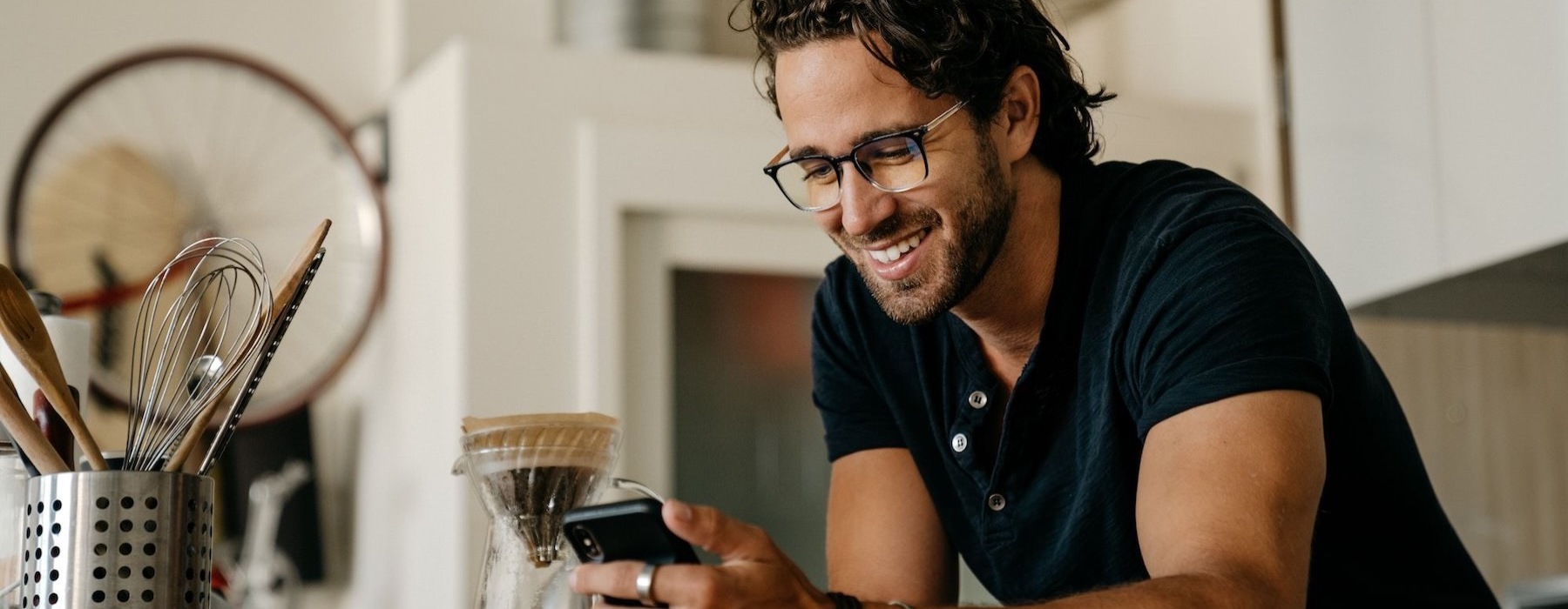 a man smiling while holding a phone